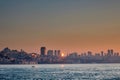Houses on the sea coast at dawn. View of the city from the sea, boats, skyscrapers at sunrise. Royalty Free Stock Photo